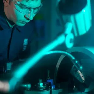 man in protective eyewear operating machinery