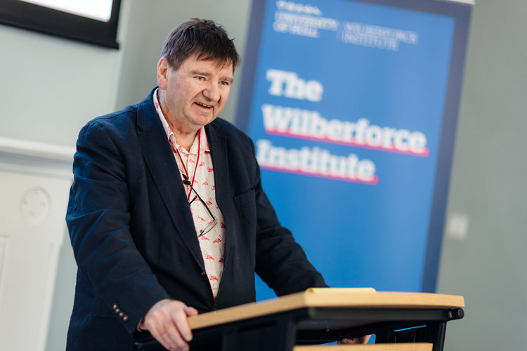 Professor Burnard hosting the Wilberforce Institute Public Lecture programme. Professor Burnard stood at lectern hosting the Wilberforce Institute Public Lecture programme.