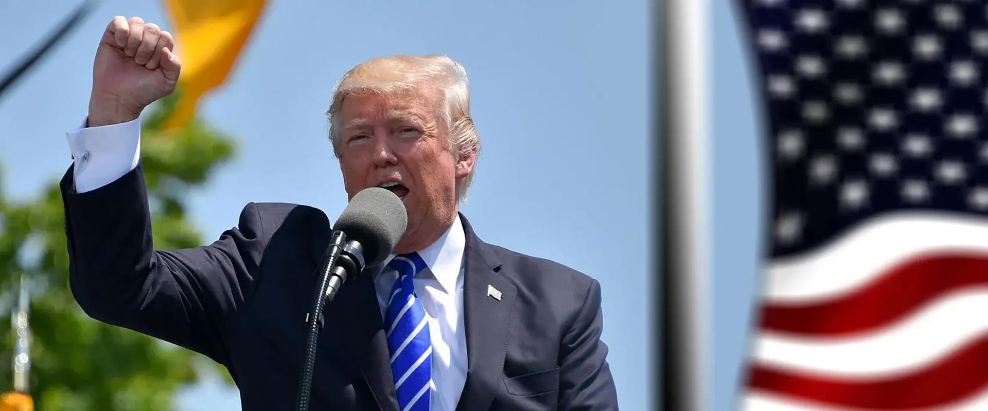President Donald Trump fist raised in front of the American flag