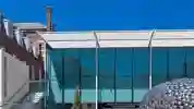 glass brick and steel structure against a blue sky