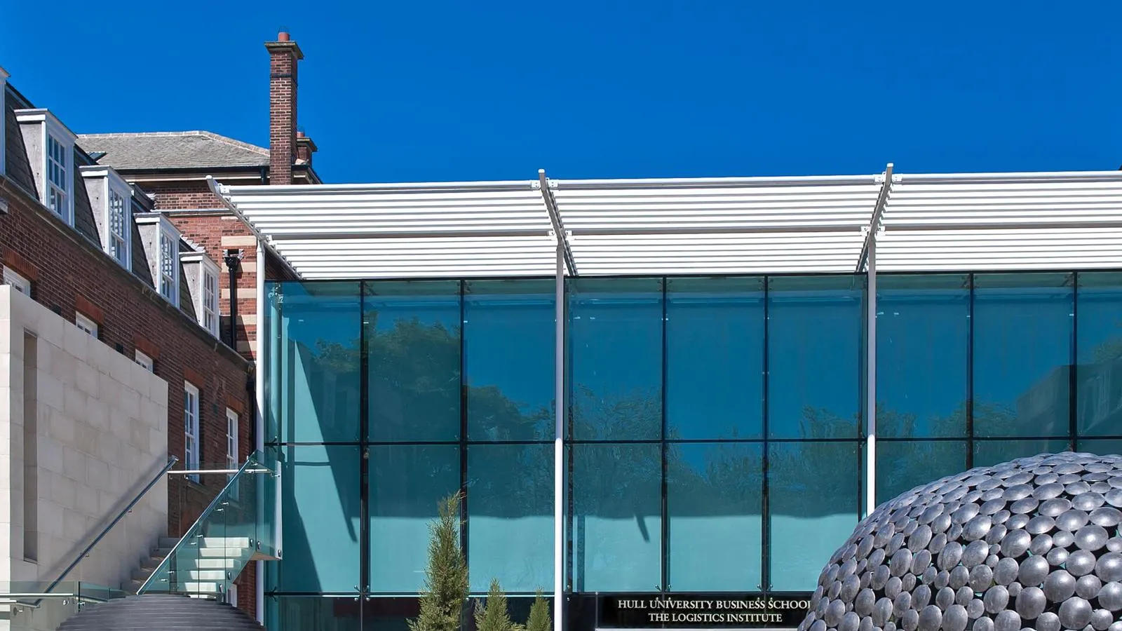 glass brick and steel structure against a blue sky