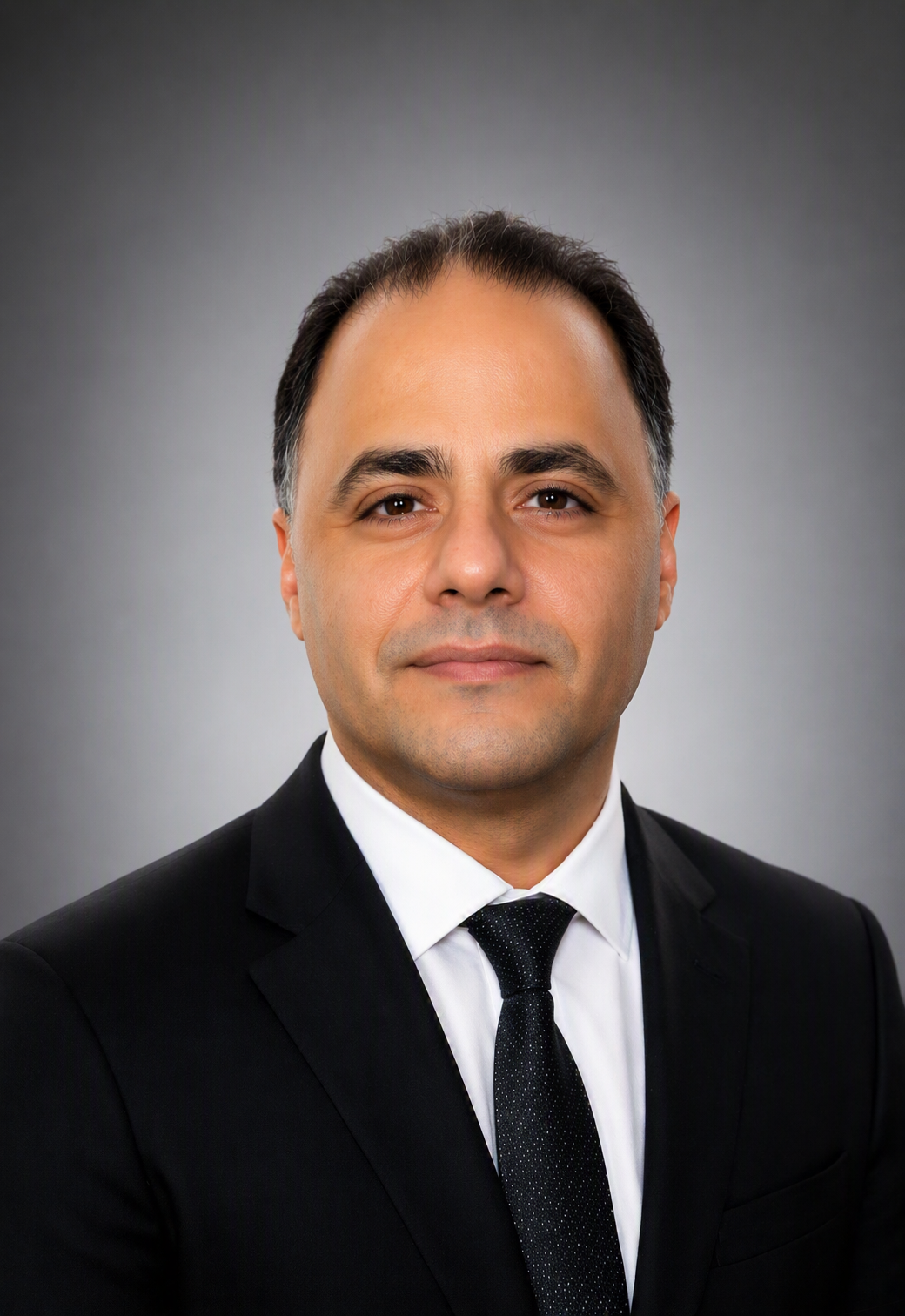 A staff member in a suit smiling at the camera.