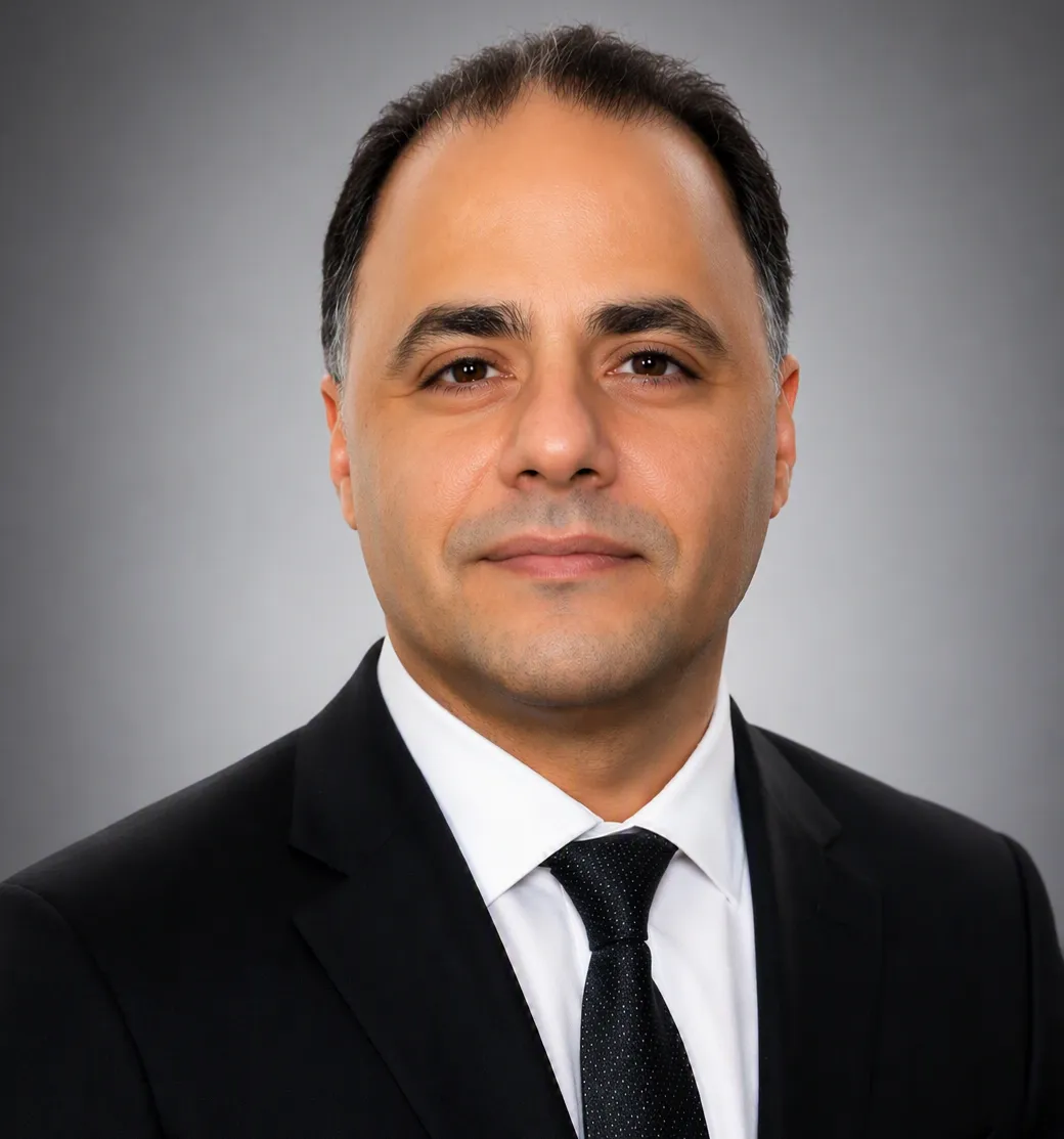 A staff member in a suit smiling at the camera.