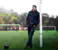 Mark Chapman standing against goal posts on sports field