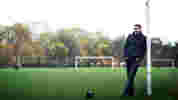 Mark Chapman standing against goal posts on sports field