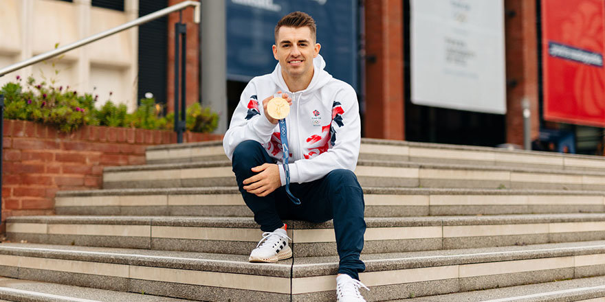 max whitlock at the university library holding a gold medal