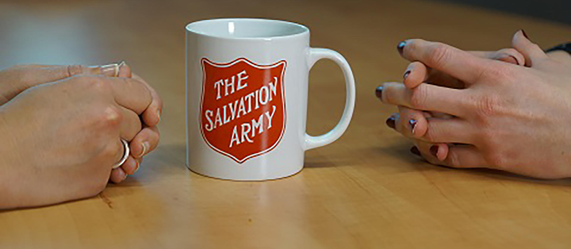 two people sat either side of a mug of tea