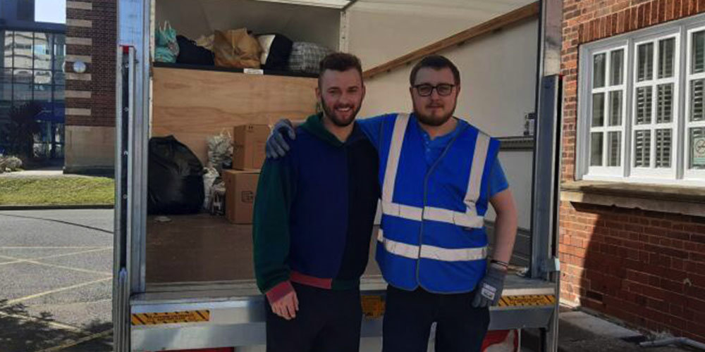 student tom bews with donations for ukraine in van