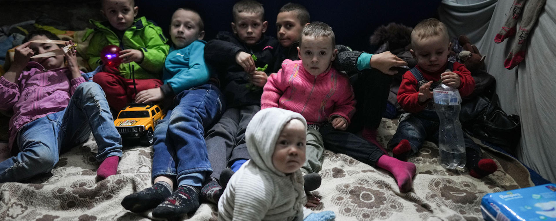 a group of children waiting in a bomb shelter for an air raid alert