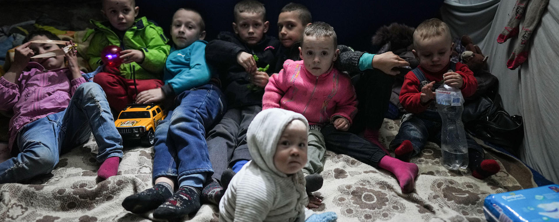 a group of children waiting in a bomb shelter for an air raid alert