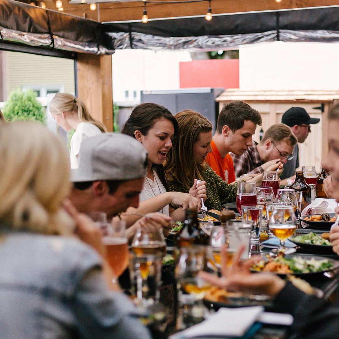 A group of students enjoying food and drinks in a cafe bar